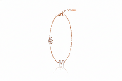Rose gold bracelet with letter 'M' charm on a white background