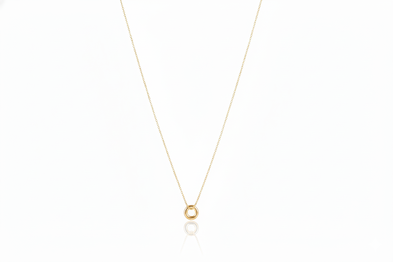 Gold necklace with a small round pendant on a white background