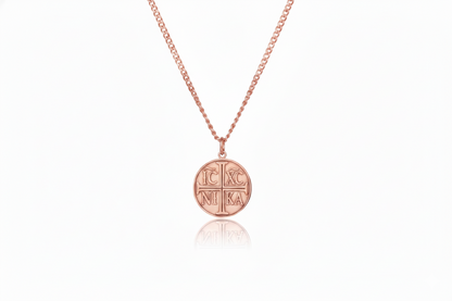 Rose gold necklace with a round pendant on a white background