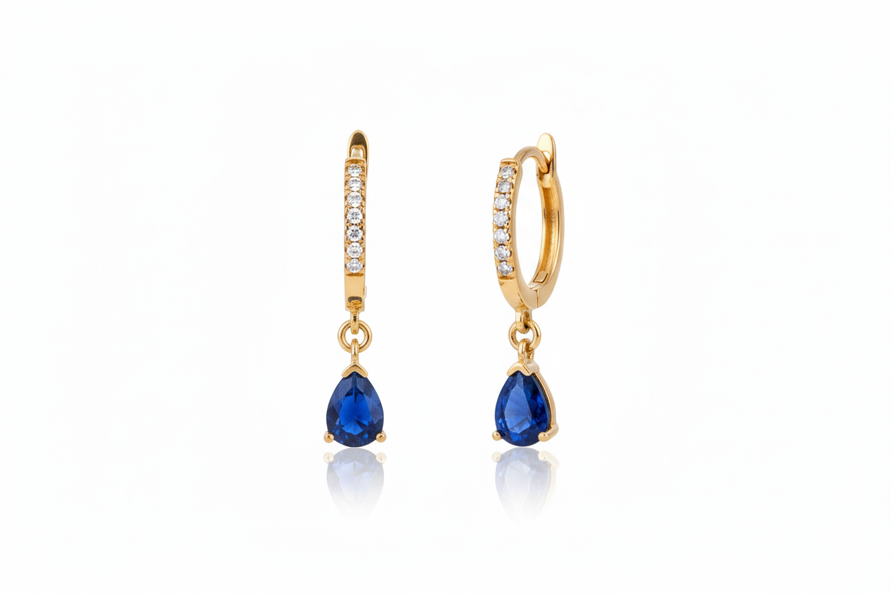 Gold earrings with blue gemstones on a white background