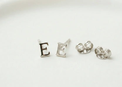 Silver letter 'E' earrings on a white background
