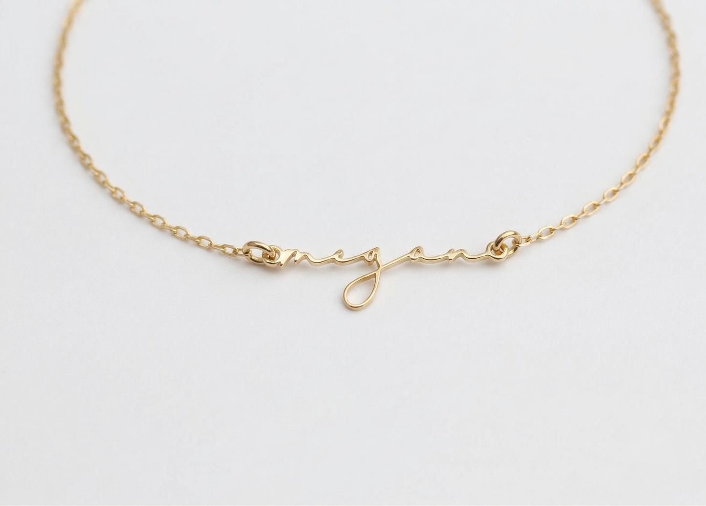 Gold bracelet on a light gray background