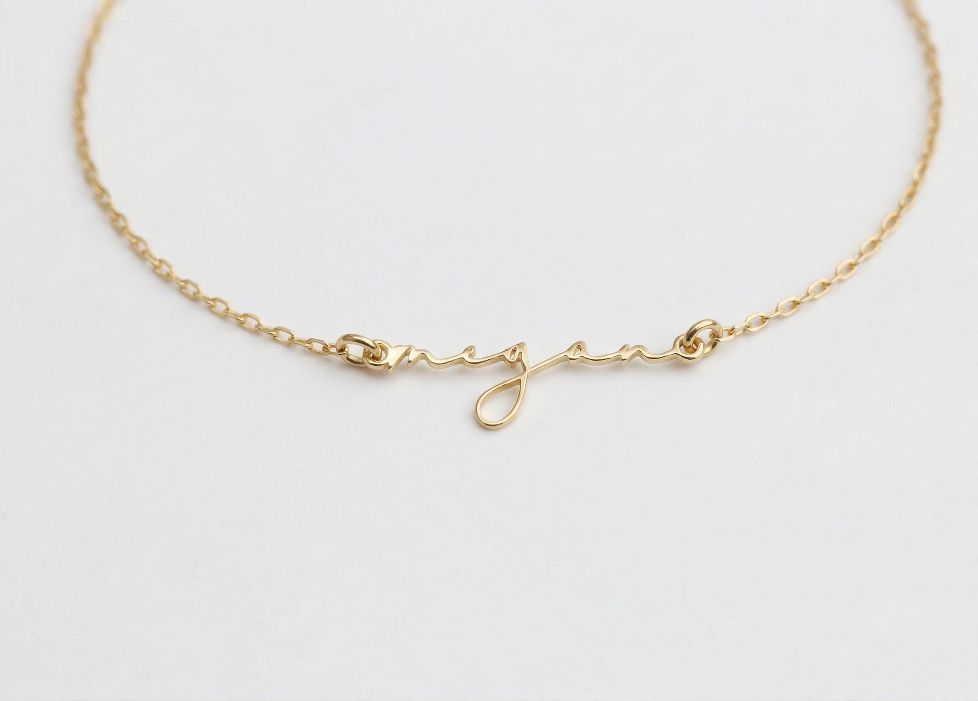 Gold bracelet on a light gray background