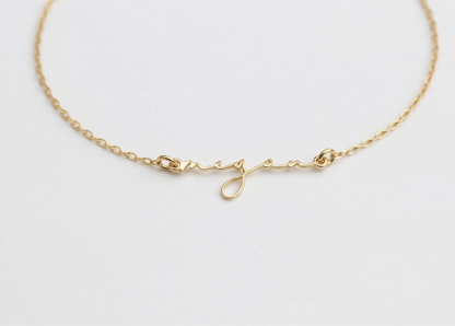 Gold bracelet on a light gray background