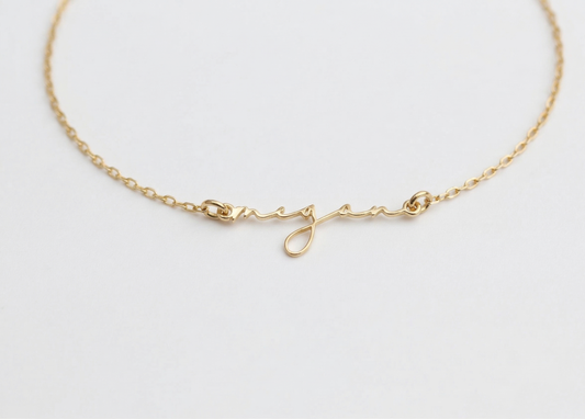 Gold bracelet on a light gray background