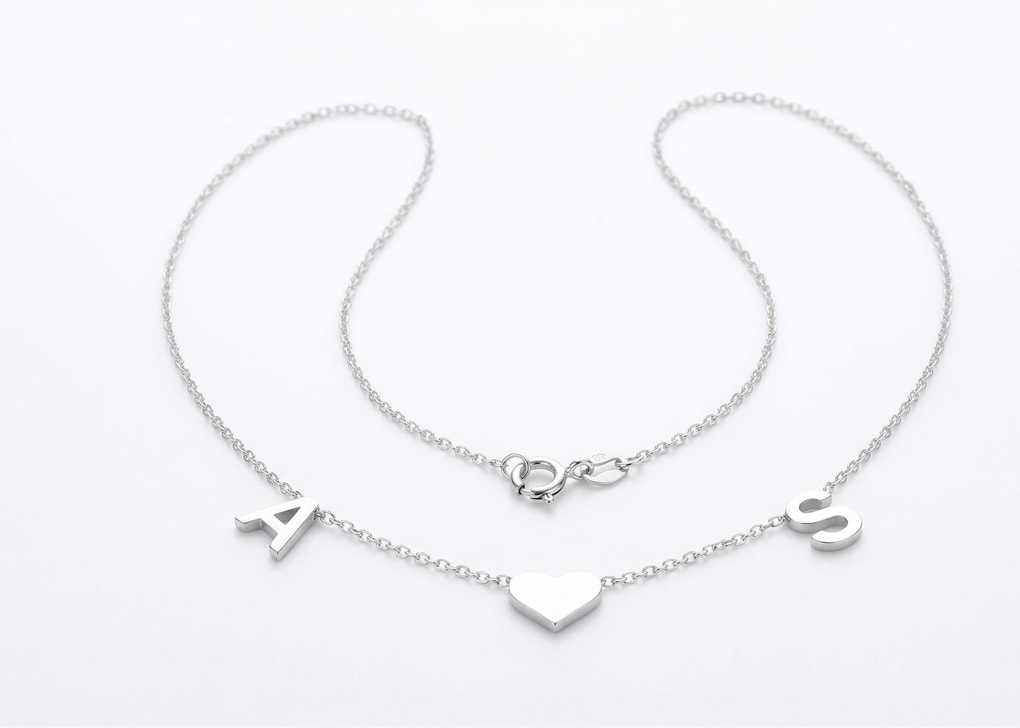 Silver bracelet with letter charms on a white background