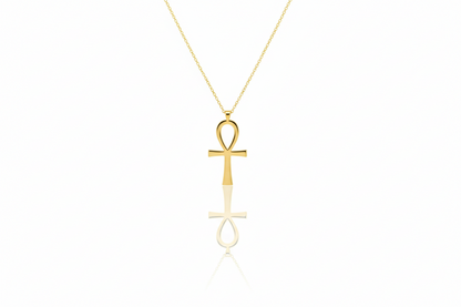 Gold ankh pendant necklace on a white background