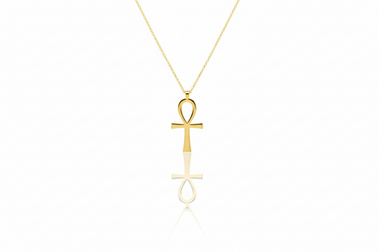 Gold ankh pendant necklace on a white background