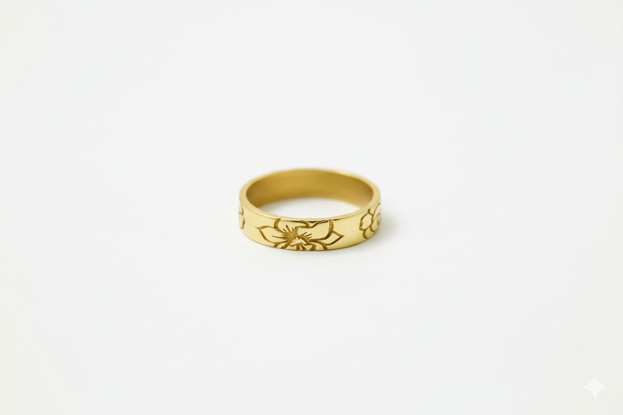 Gold ring with floral design on a white background