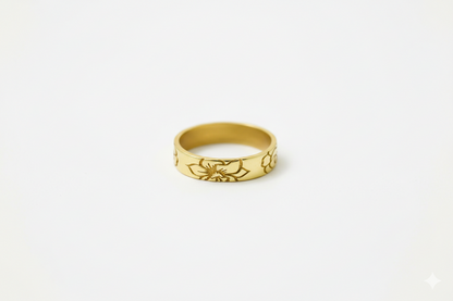 Gold ring with floral design on a white background