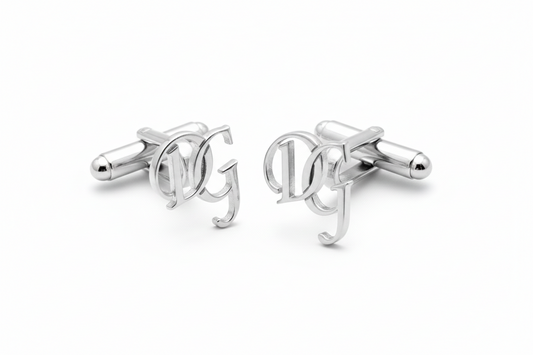 Silver cufflinks with 'DG' initials on a white background