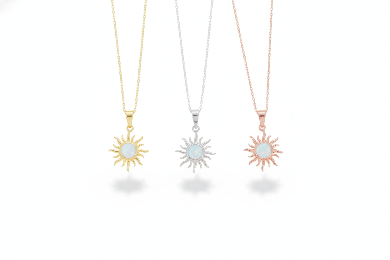 Three sun-shaped necklaces in gold, silver, and rose gold on a white background