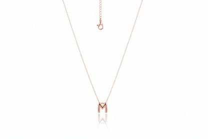 Rose gold necklace with a 'M' pendant on a white background