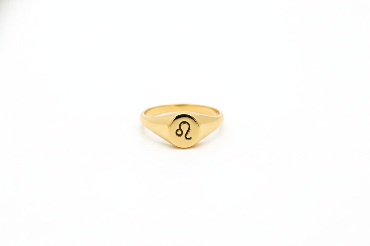 Gold ring with a zodiac symbol on a white background