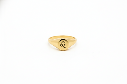 Gold ring with a zodiac symbol on a white background