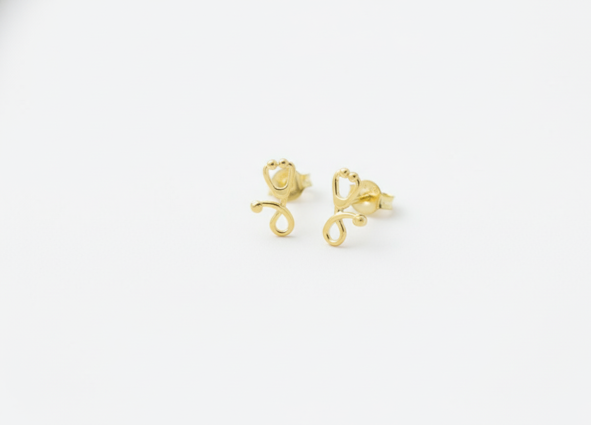 Gold monkey-shaped earrings on a white background