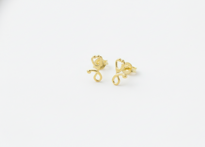 Gold monkey-shaped earrings on a white background
