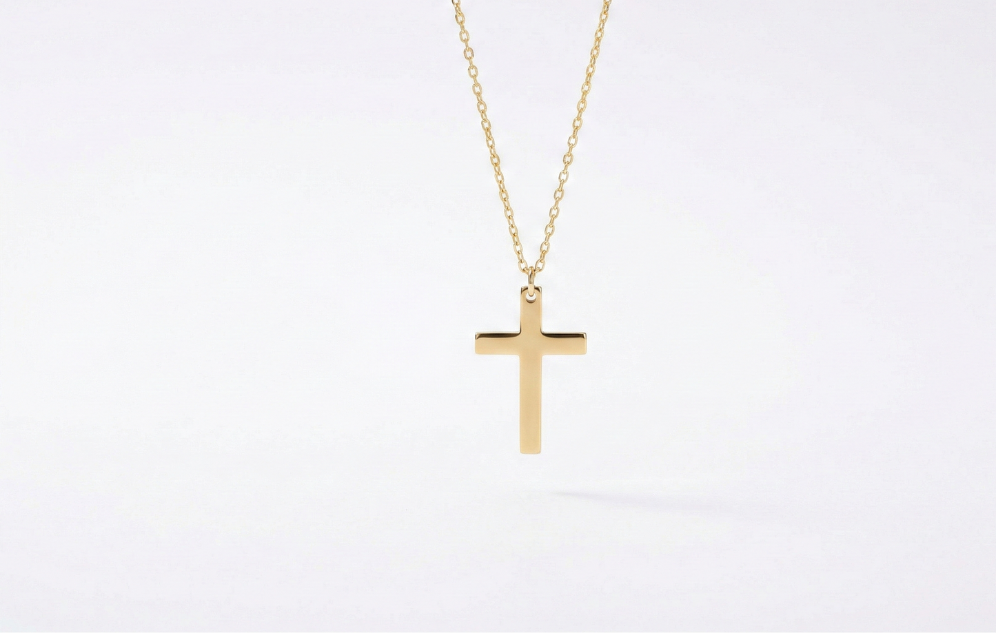 Gold cross necklace on a white background