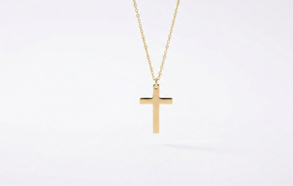 Gold cross necklace on a white background