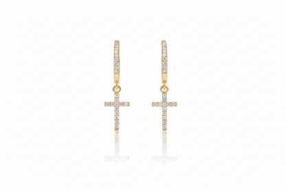 Gold cross earrings with clear stones on a white background