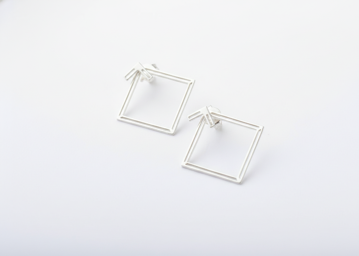 Silver square hoop earrings on a white background
