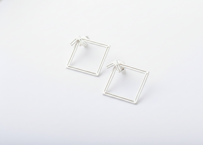 Silver square hoop earrings on a white background