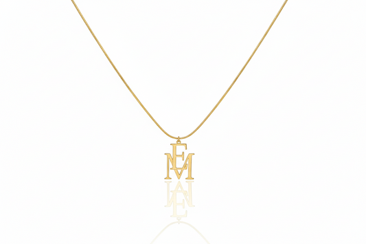 Gold necklace with 'EM' pendant on a white background