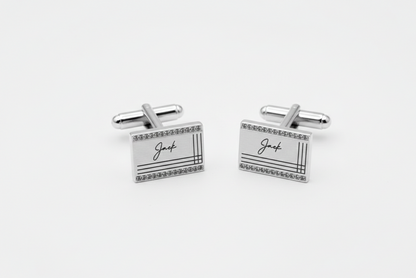Pair of silver rectangular cufflinks with 'Jack' engraving on a white background