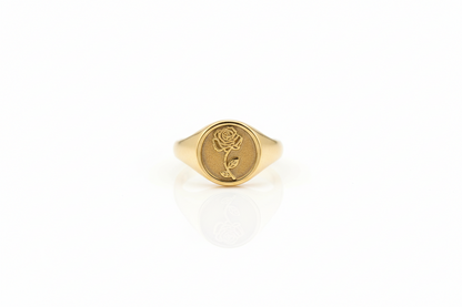 Gold ring with a rose design on a white background