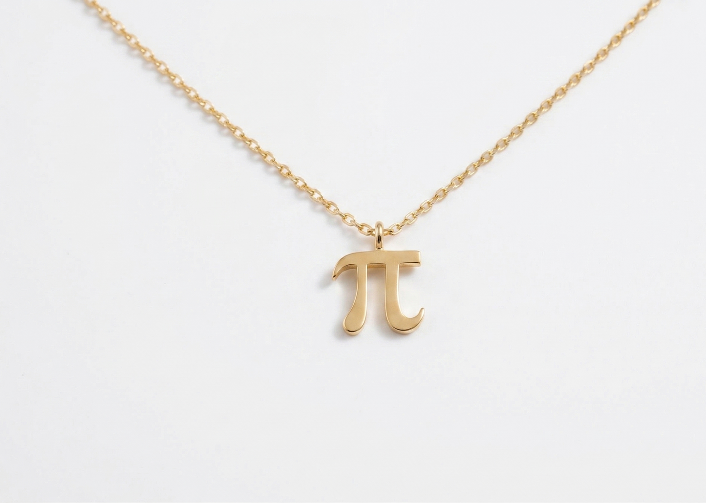 Gold necklace with a pi symbol pendant on a white background