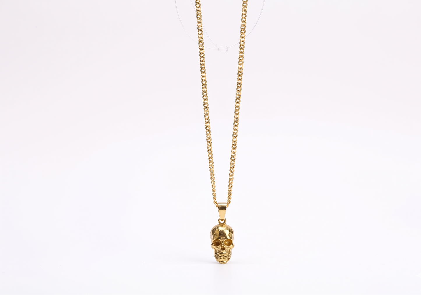 Gold skull pendant necklace on a white background