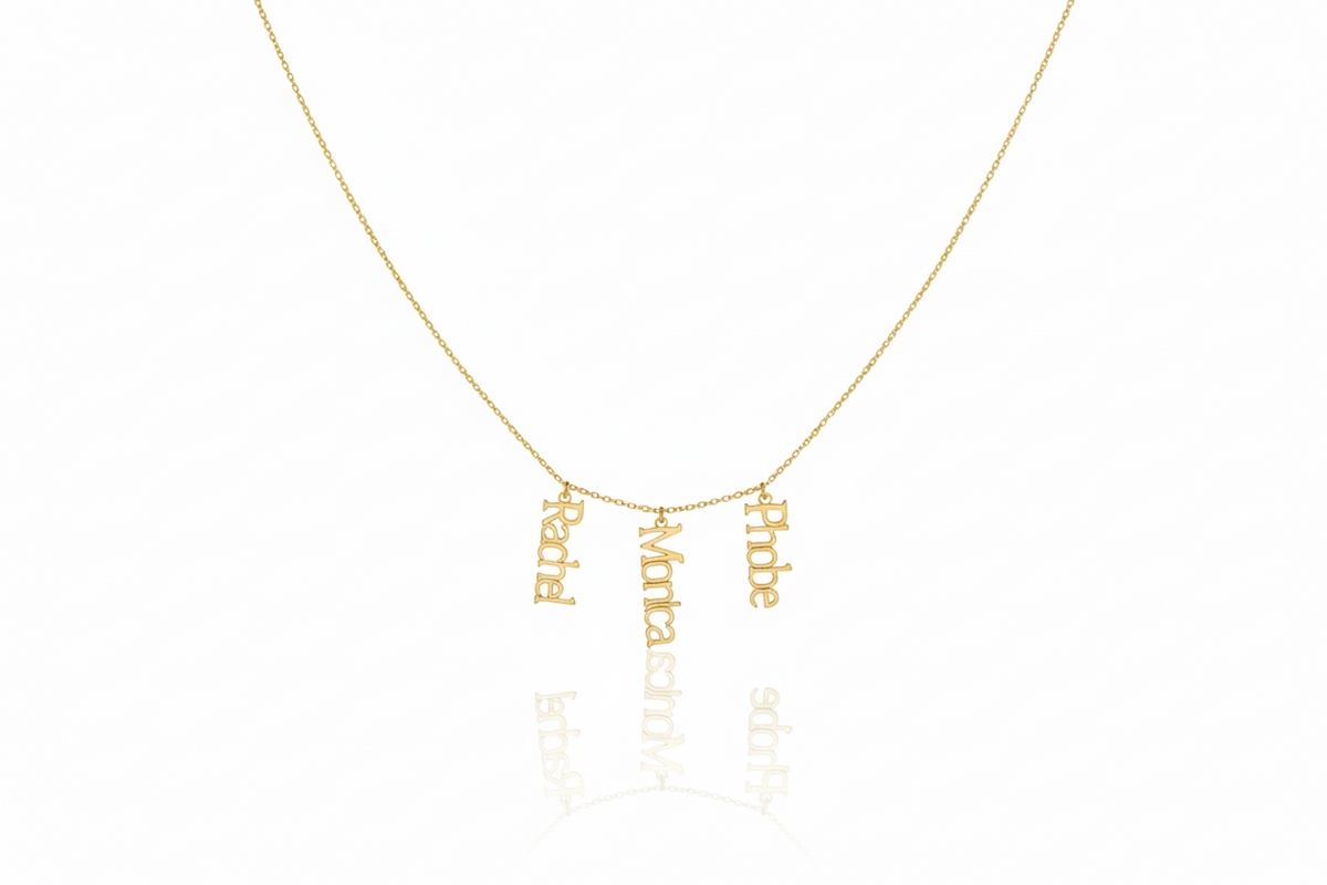 Gold necklace with engraved names on a white background