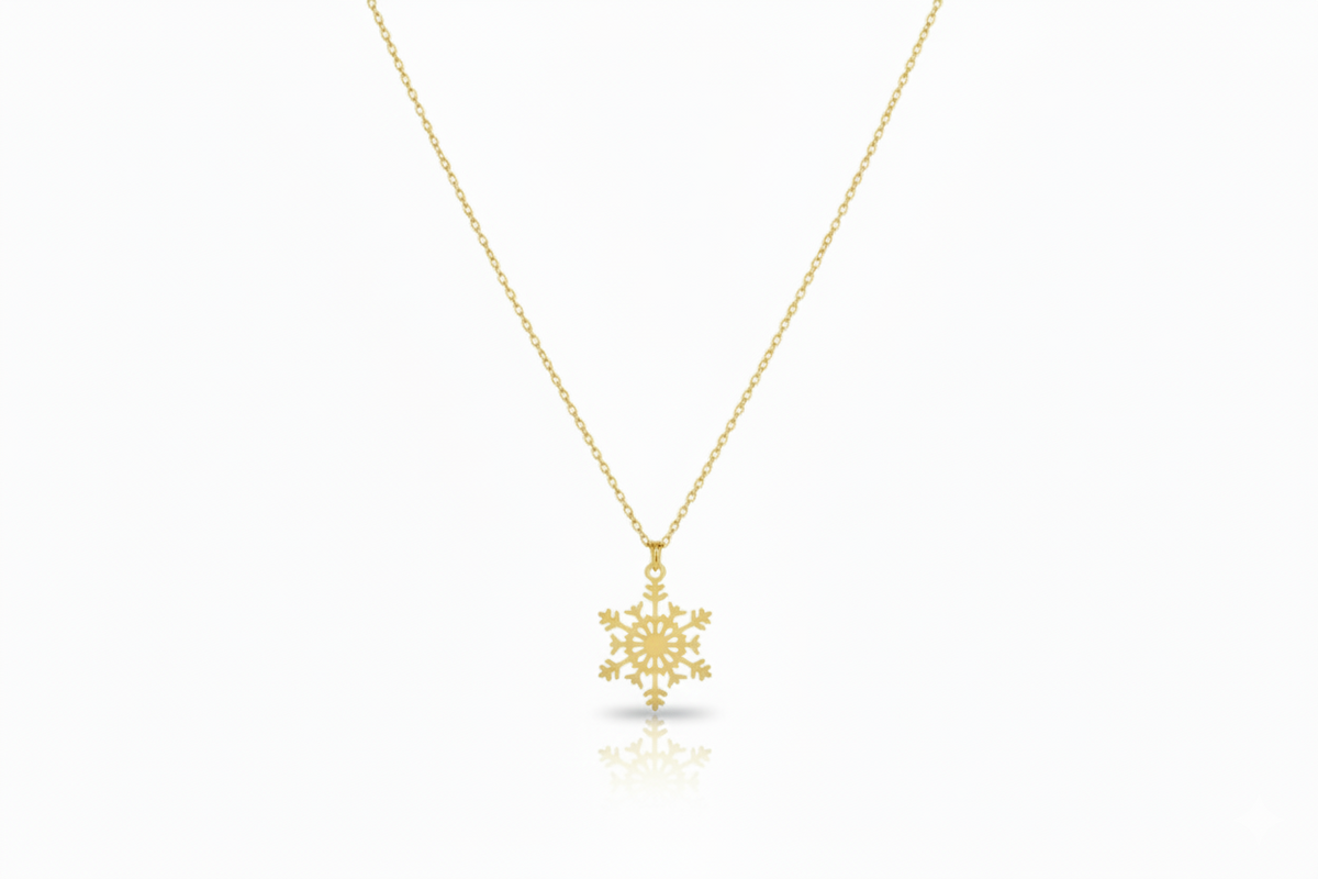 Gold snowflake pendant necklace on a white background