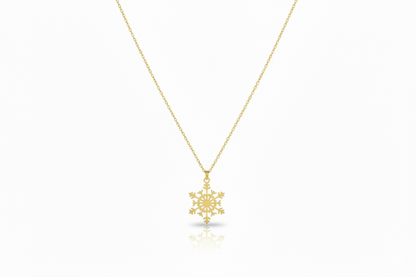 Gold snowflake pendant necklace on a white background