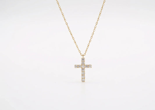 Gold cross necklace with diamonds on a white background