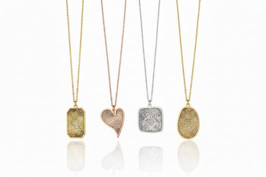 Four gold necklaces with different pendants on a white background