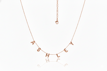 Rose gold necklace with 'ASHLEY' letters on a white background