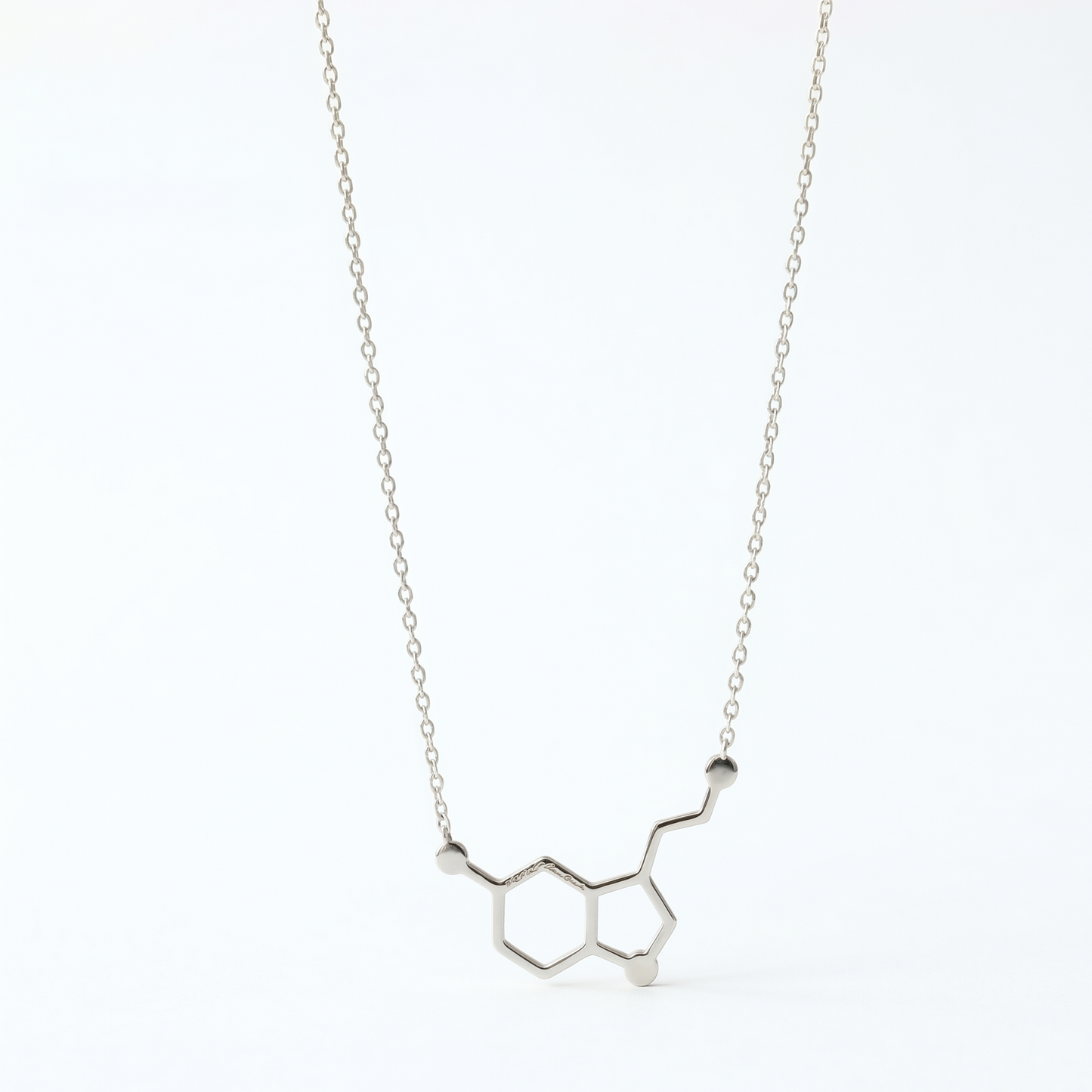 Silver necklace with molecular design on a white background