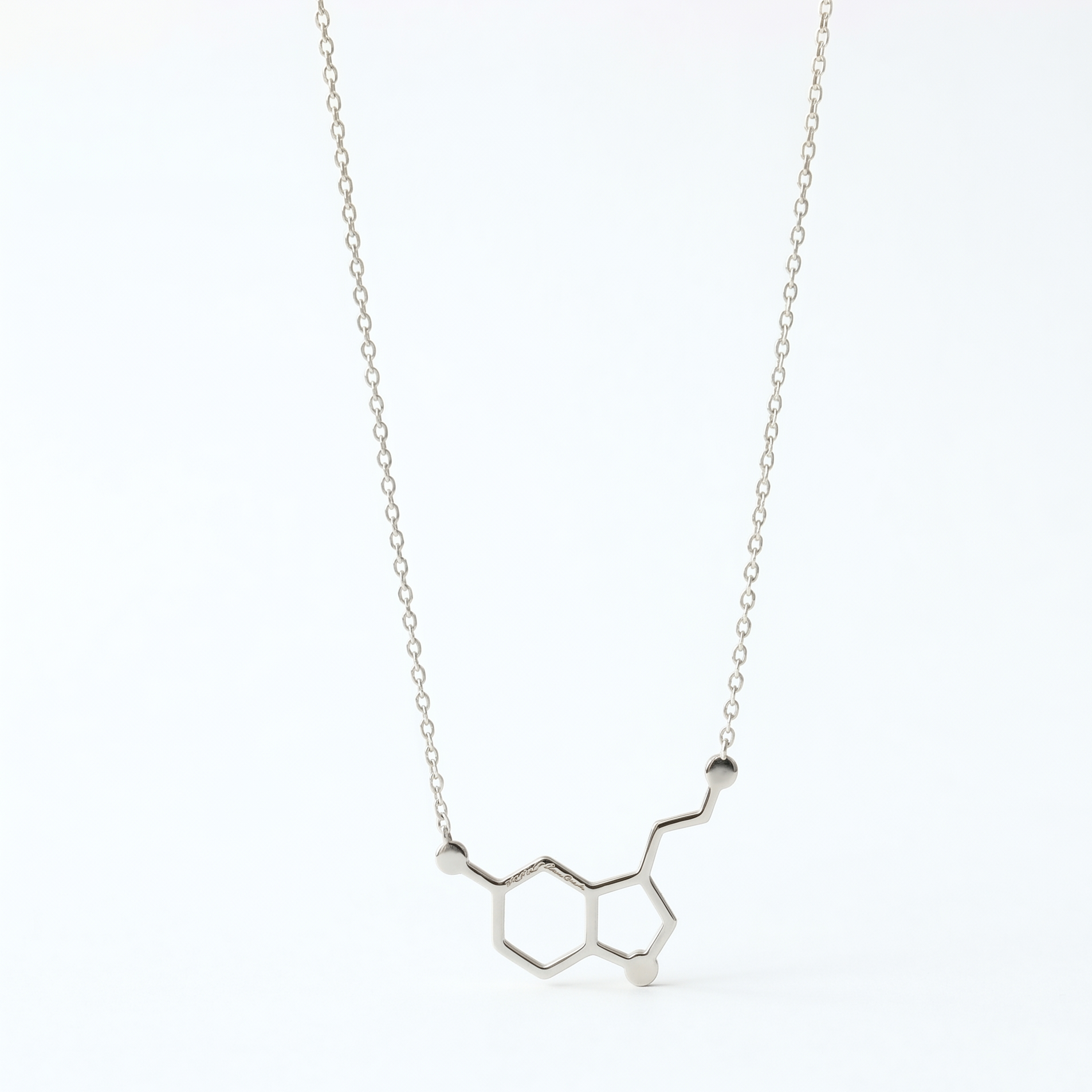 Silver necklace with molecular design on a white background