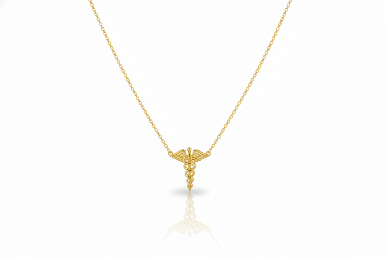 Gold necklace with a caduceus pendant on a white background