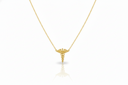 Gold necklace with a caduceus pendant on a white background