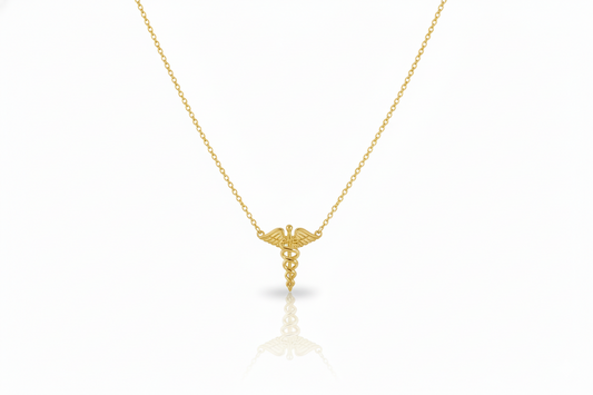 Gold necklace with a caduceus pendant on a white background