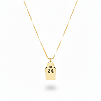 Gold necklace with a pendant shaped like a basketball jersey on a white background