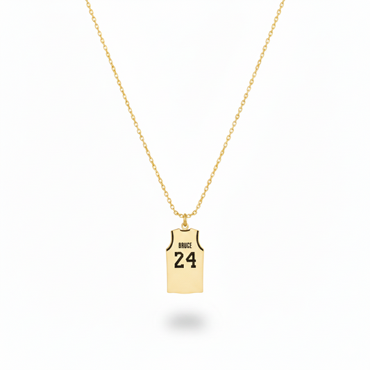 Gold necklace with a pendant shaped like a basketball jersey on a white background