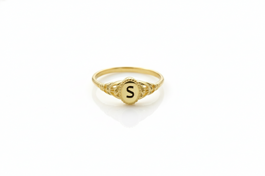 Gold ring with a letter 'S' on a white background