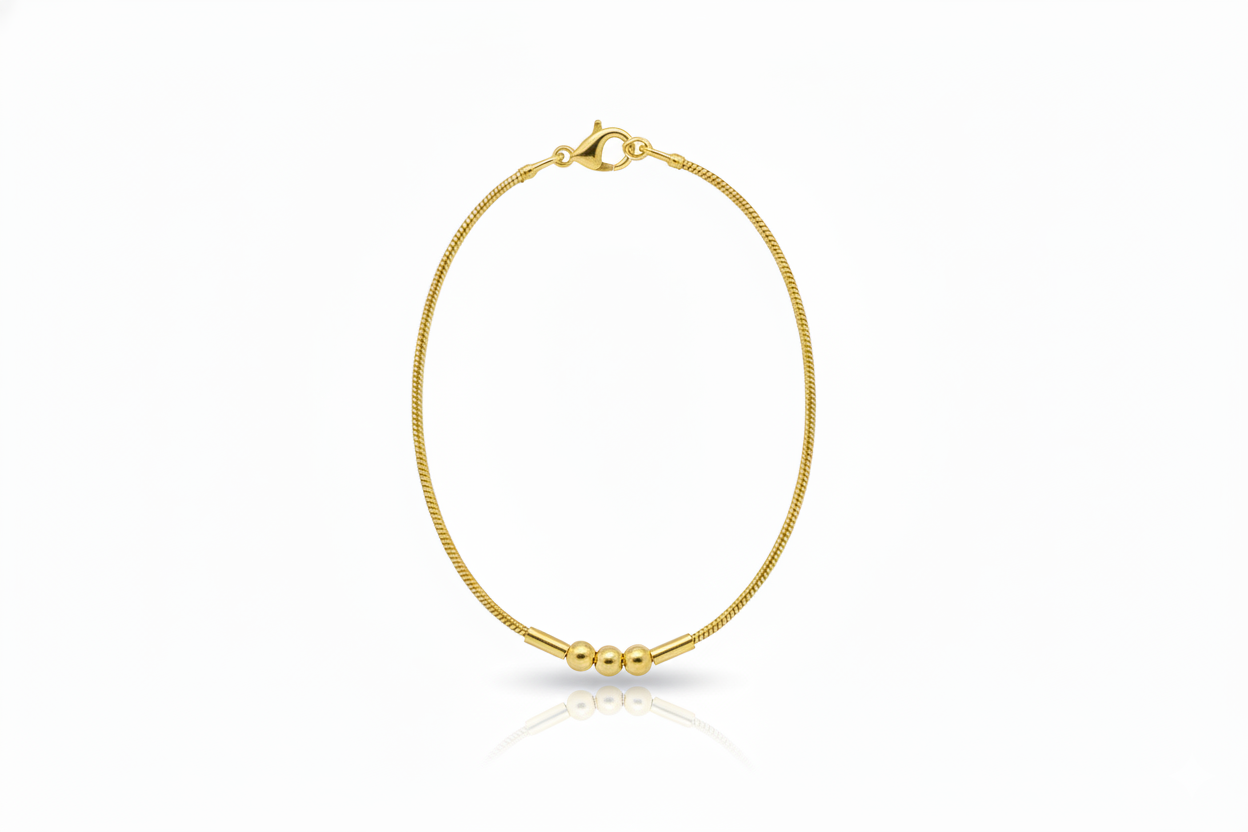 Gold bracelet with three beads on a white background