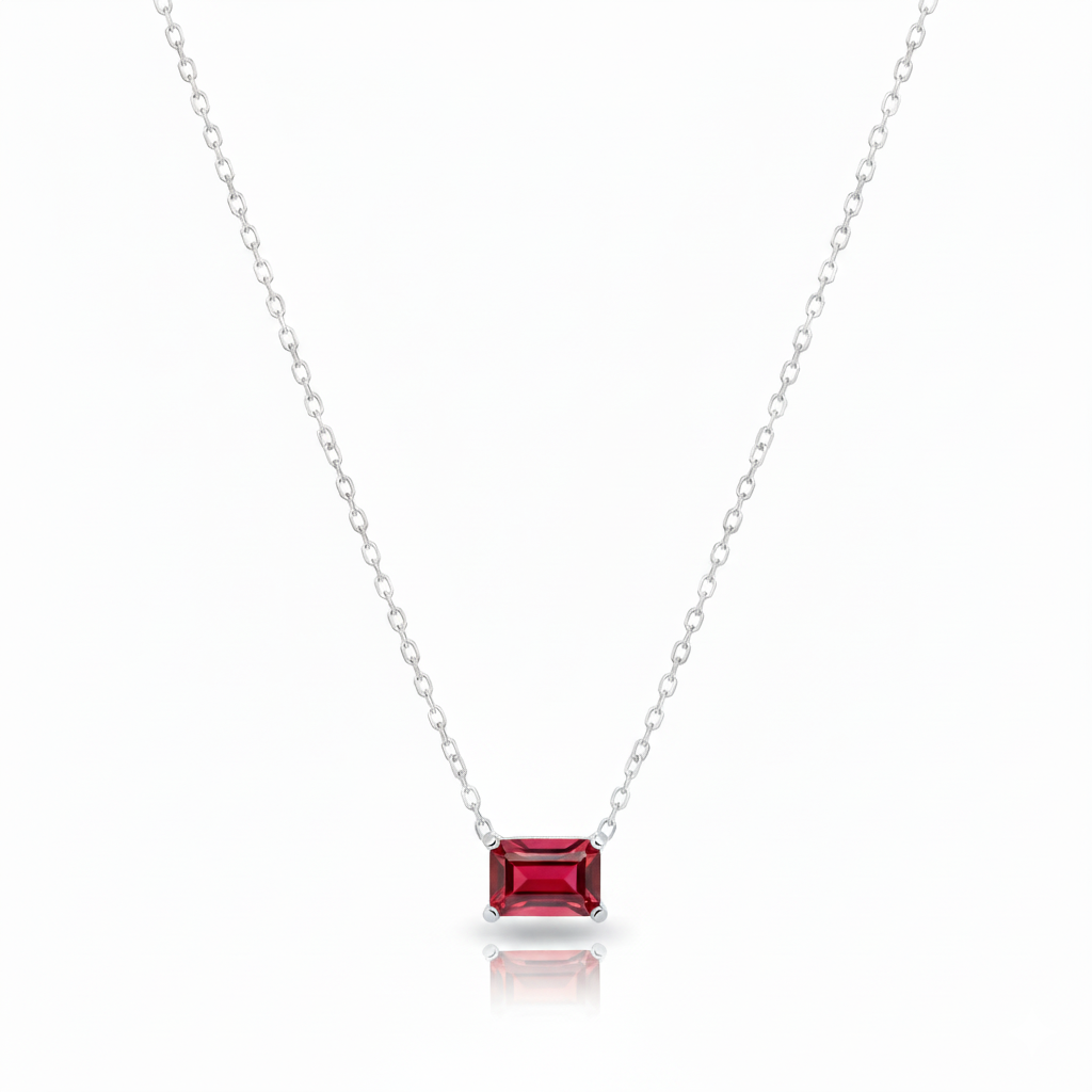 Silver necklace with a red gemstone pendant on a white background