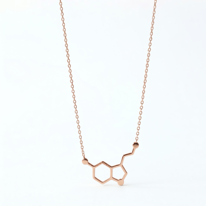 Rose gold molecular pendant necklace on a white background