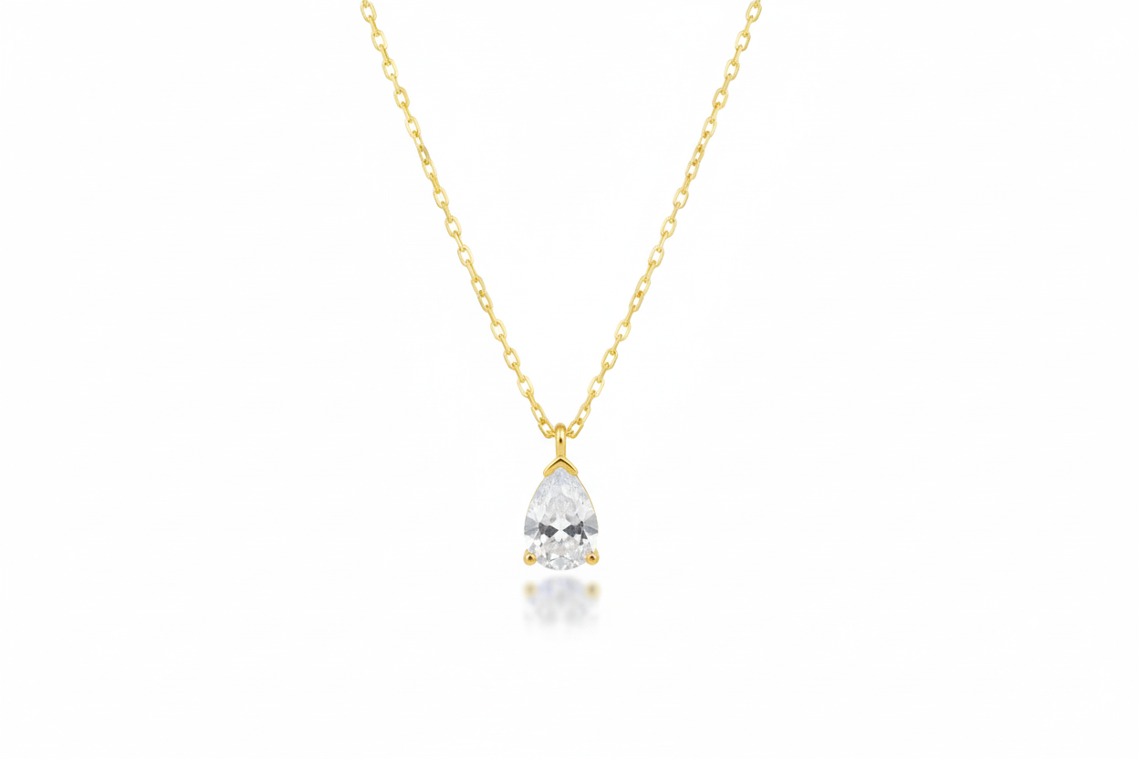 Gold necklace with a teardrop-shaped diamond pendant on a white background