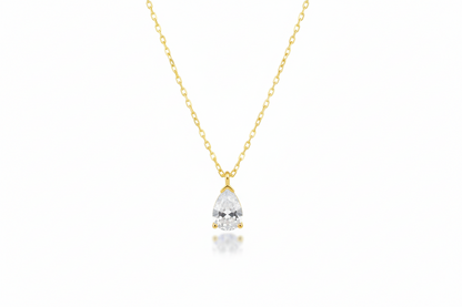 Gold necklace with a teardrop-shaped diamond pendant on a white background